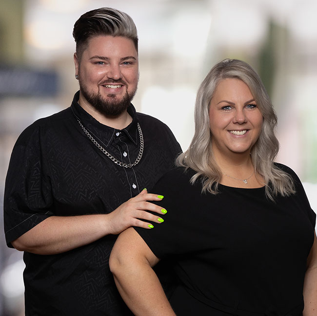 Die Ausbilder Cornelia und Andreas lächeln in die Kamera.